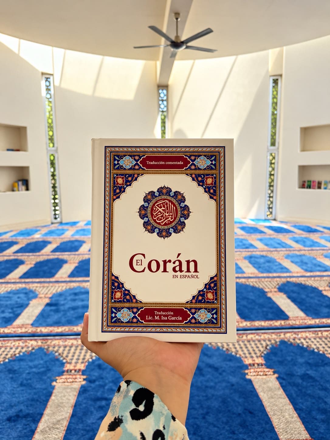 Un ejemplar del Corán en español, sostenido dentro de una mezquita